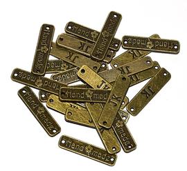 Našívací kovová značka 25x6 mm HAND MADE